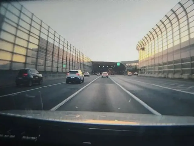 ผู้หญิงคนหนึ่งยืนอยู่บนอุโมงค์เก็บเสียงบนทางหลวง "ผี?" ถูกพบบนทางด่วน Yongdong ใ