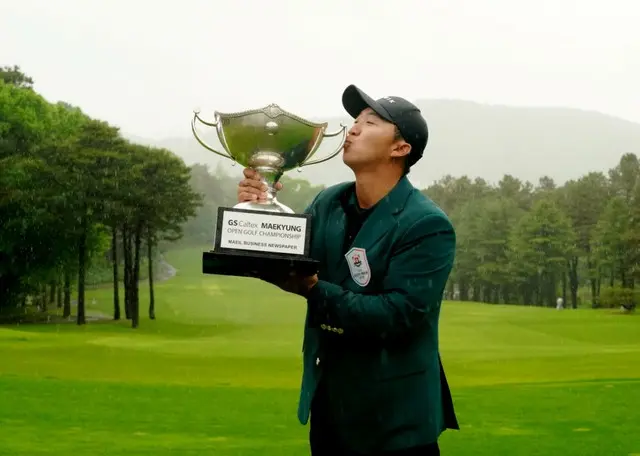 優勝トロフィーを手にしたキム・ホンテク（写真：大会組織委員会）