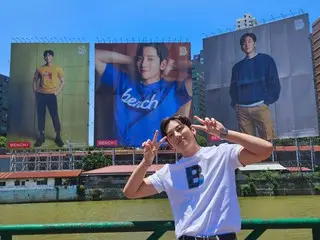 นักแสดงจีชางอุคถ่ายภาพรับรองด้วยโฆษณาขนาดใหญ่ของเขาในกรุงมะนิลา ประเทศฟิลิปปินส์
