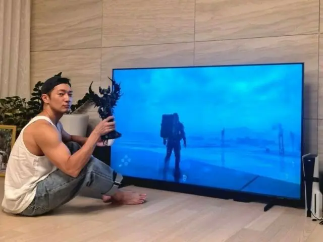 ซนซุกกูกำลังนั่งอยู่บนพื้นหน้าทีวี จดจ่ออยู่กับการเล่นเกม... อีดงฮวีพูดว่า "ฉันจะส่งขาตั้งทีวีไปให้คุณไหม?"